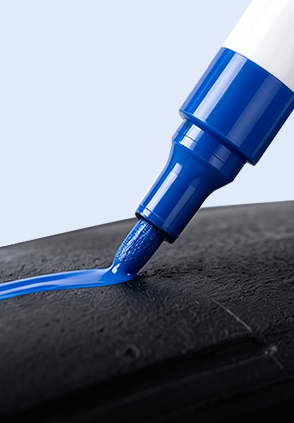 Blue tire paint marker tip applying color to rubber