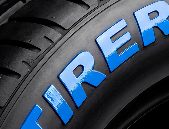 Glossy blue painted lettering on a tire